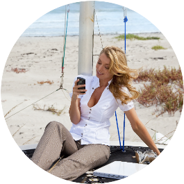 woman on beach with phone symbolizes the qualities of a great coach